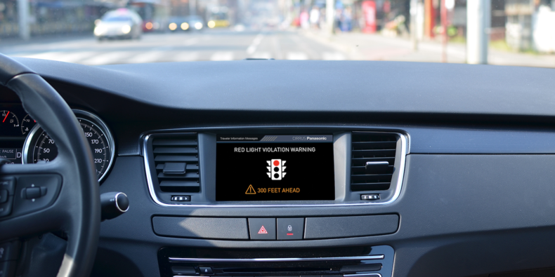 a vehicle infotainment unit shows a real-time red light violation warning